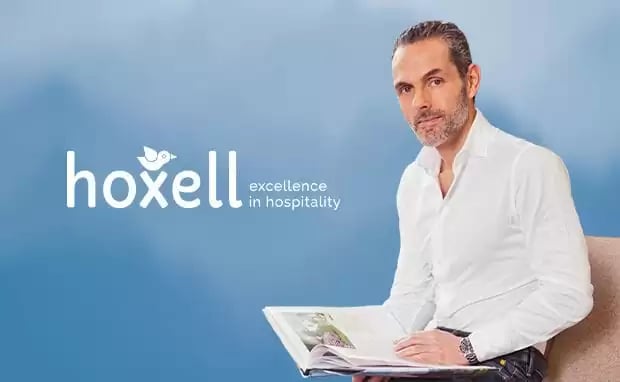 Hoxell Guest Experience Plattform mit Logo und Person als Symbol für digitale Exzellenz in der Hotellerie