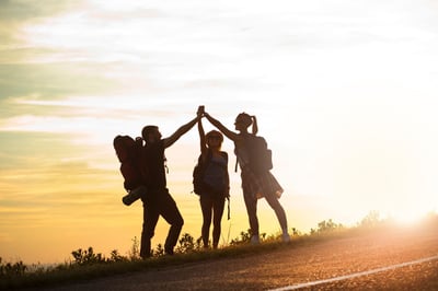 Drei wandernde Personen im Sonnenlicht